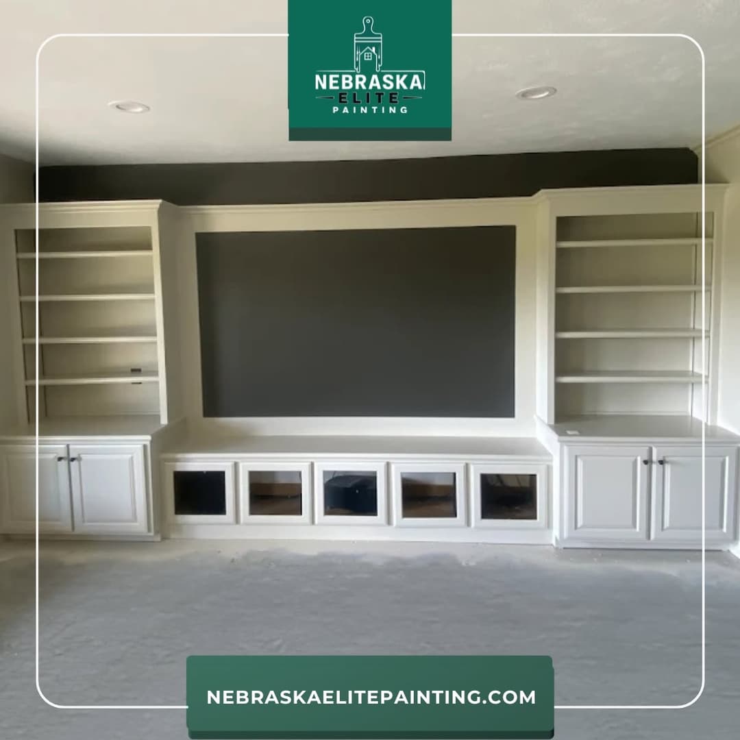 Custom built-in shelves with white cabinetry and a grey accent wall in a modern living space.
