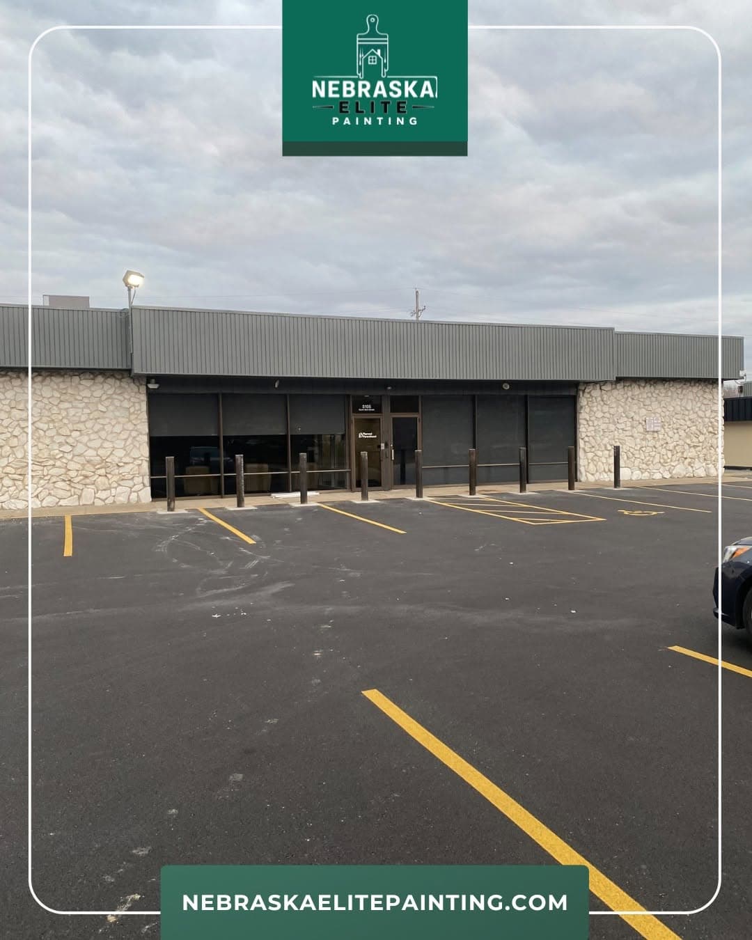 Exterior view of Nebraska Elite Painting location with ample parking and cloudy sky.
