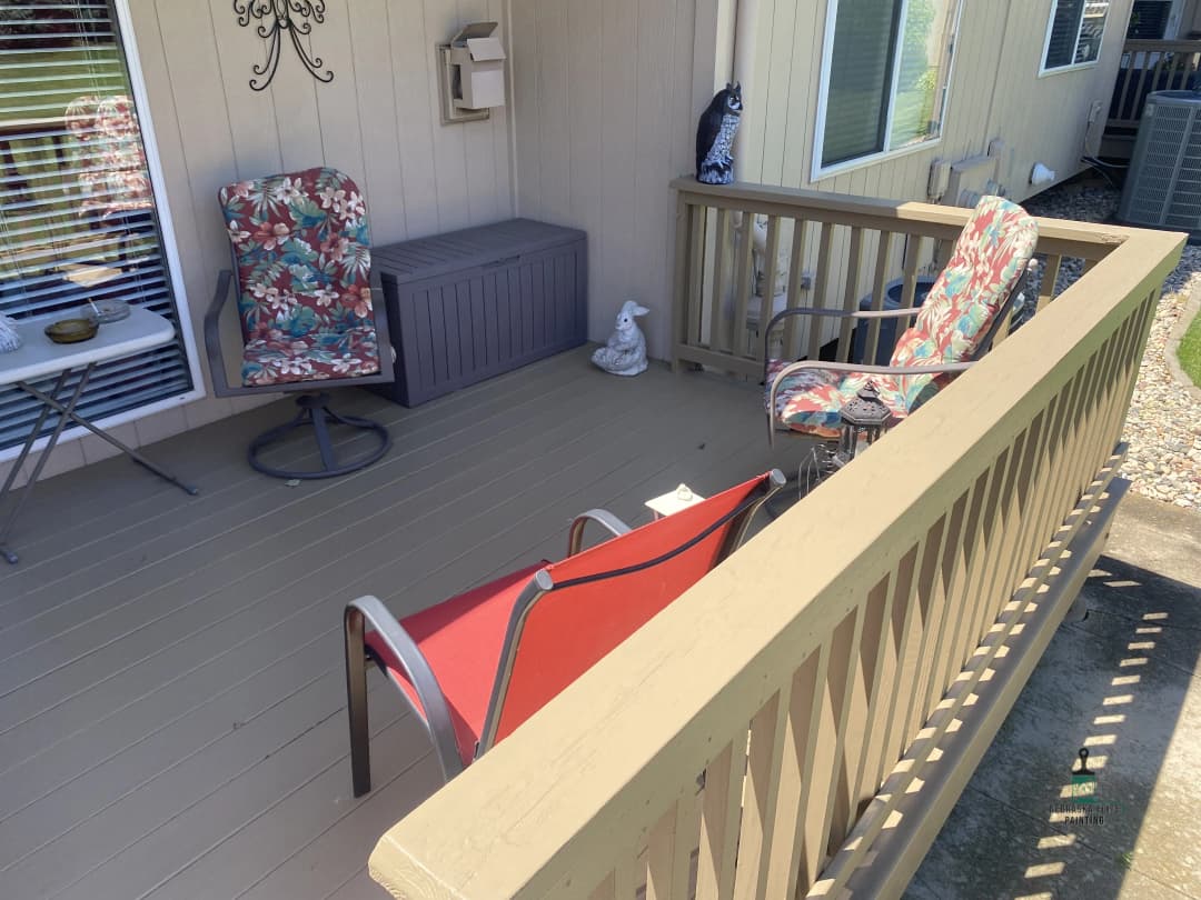 Cozy outdoor patio featuring floral chairs, a storage box, and decorative accents.
