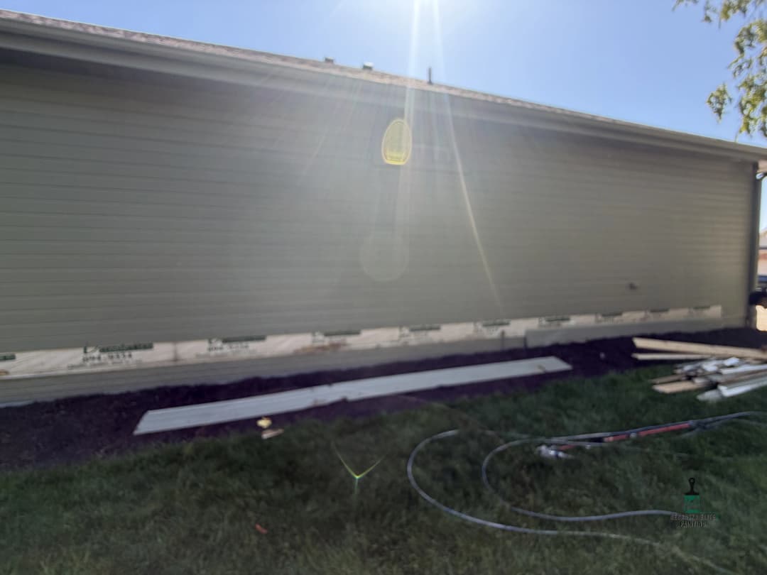 Newly installed siding on a residential home with construction materials in the foreground.