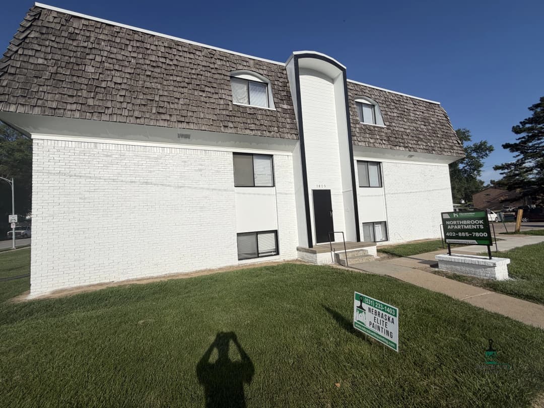 Northbrook Apartments exterior view with signage, green lawn, and clear blue sky.