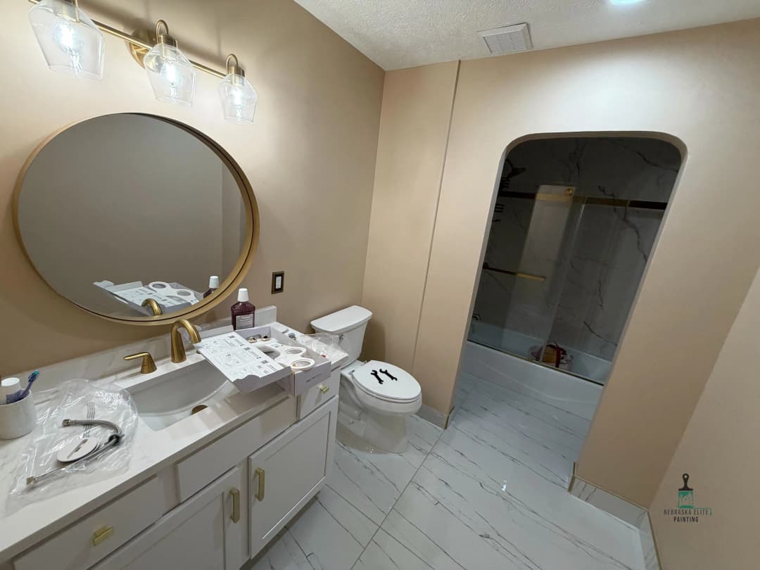 Modern bathroom interior with elegant fixtures, a round mirror, and a spacious shower area.