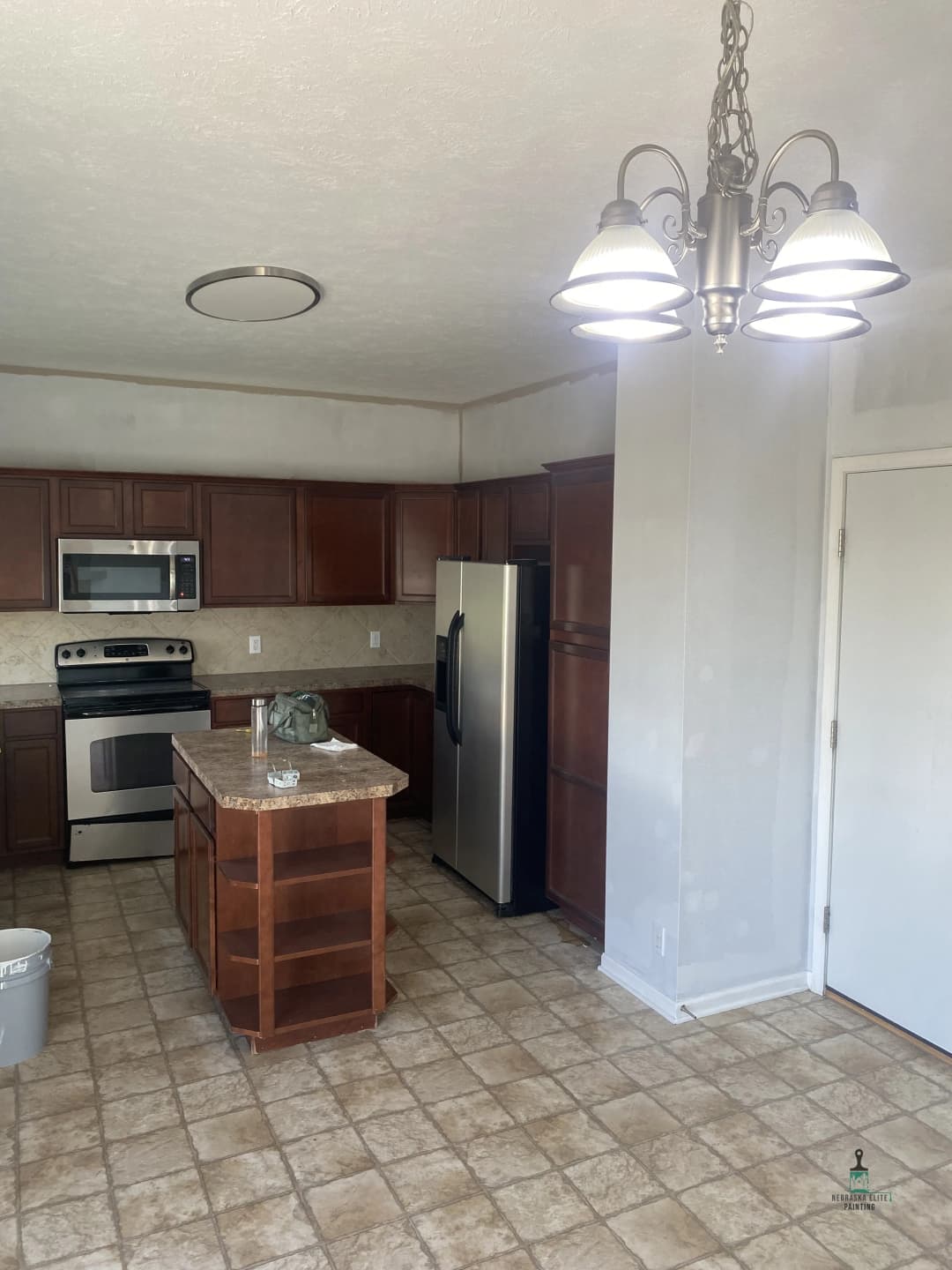 Modern kitchen with stainless steel appliances, wooden cabinets, and pendant lighting.