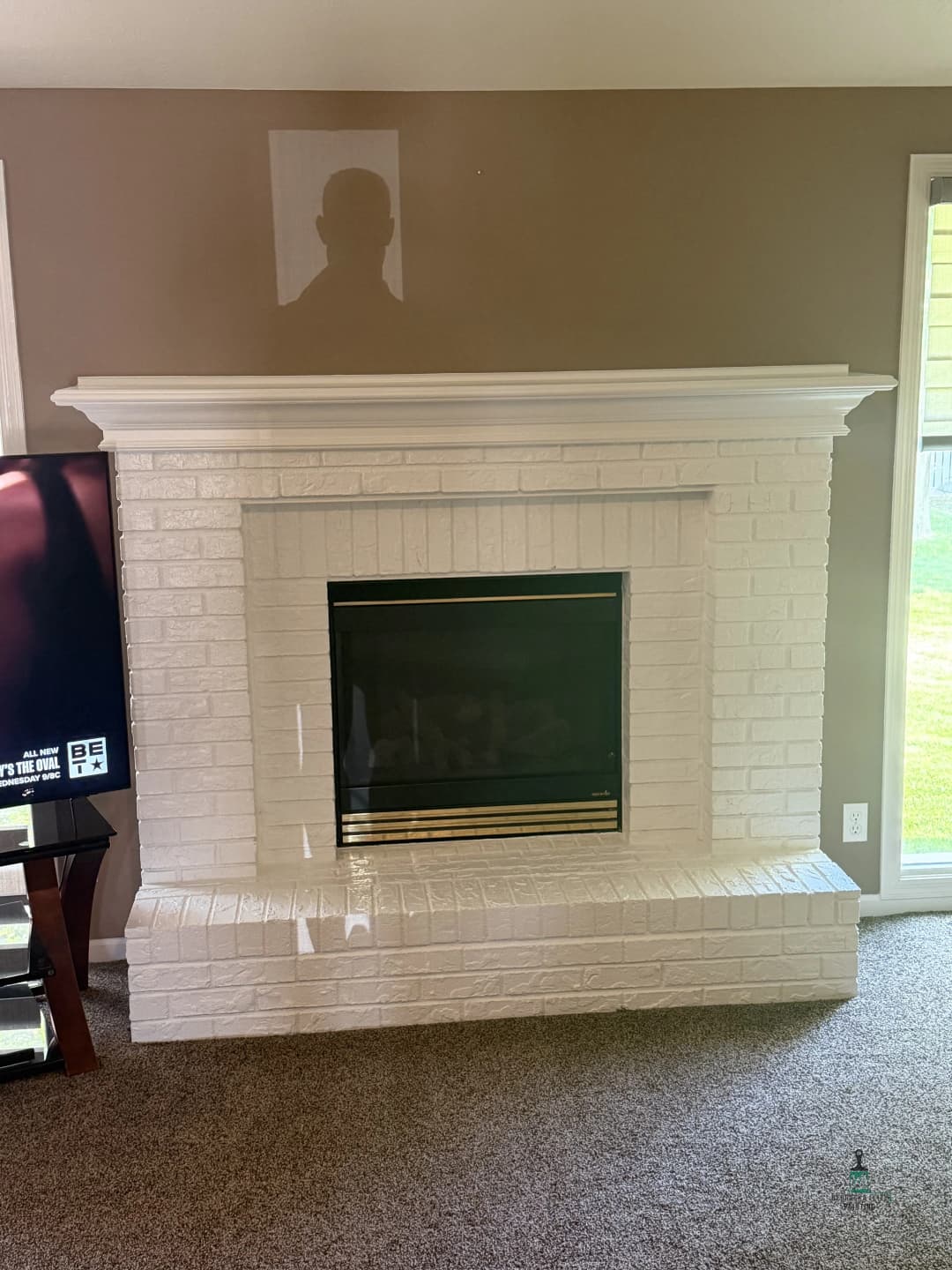 White brick fireplace with black trim in a modern living room setting.