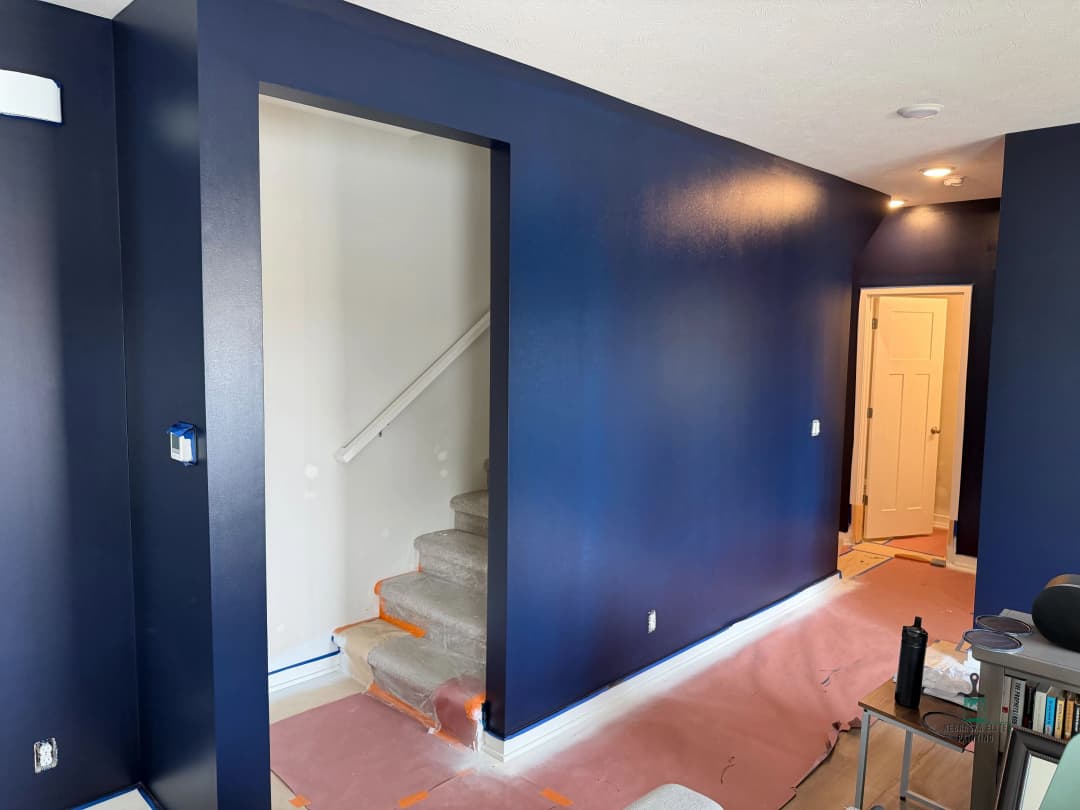 Modern interior with navy blue walls, carpeted stairs, and transitional hallway.