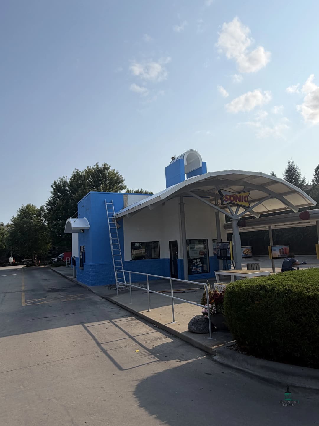 Sonic Drive-In restaurant exterior with blue accents and accessible ramp on a sunny day.