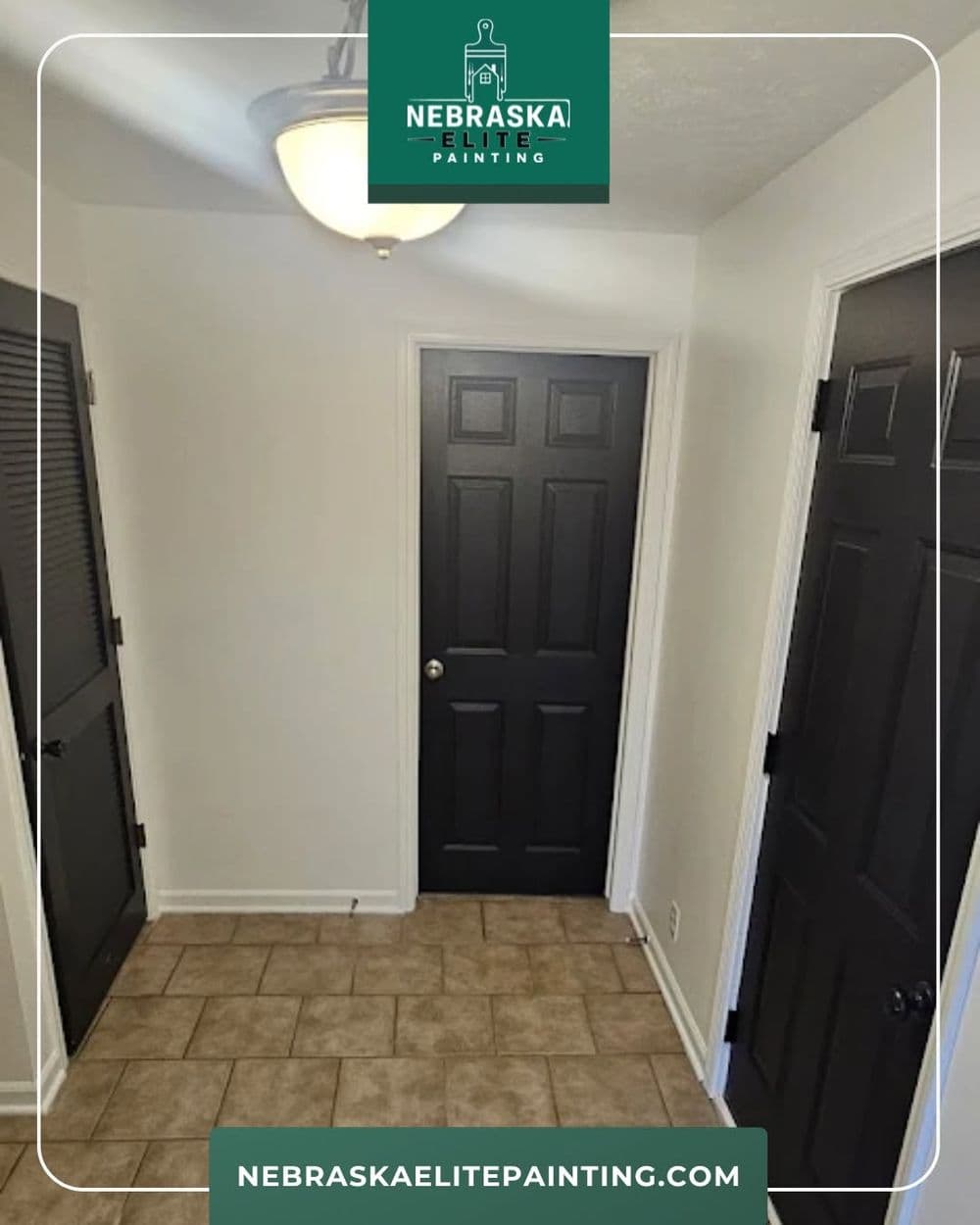 Entrance hallway featuring three black doors and neutral tiled flooring, well-lit by a ceiling fixture.