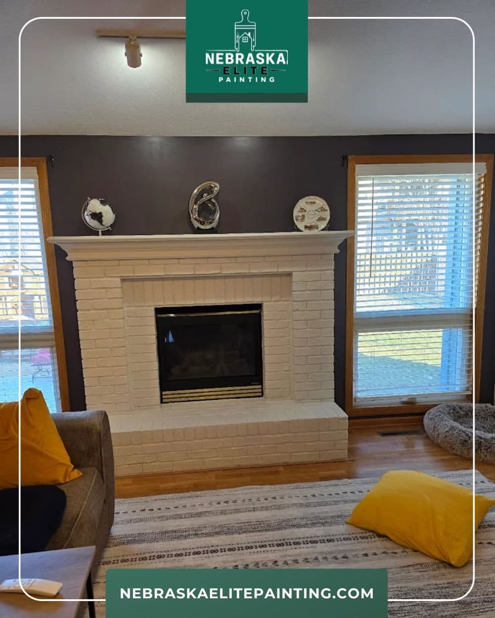 Modern living room with a white brick fireplace, wooden floors, and natural light.