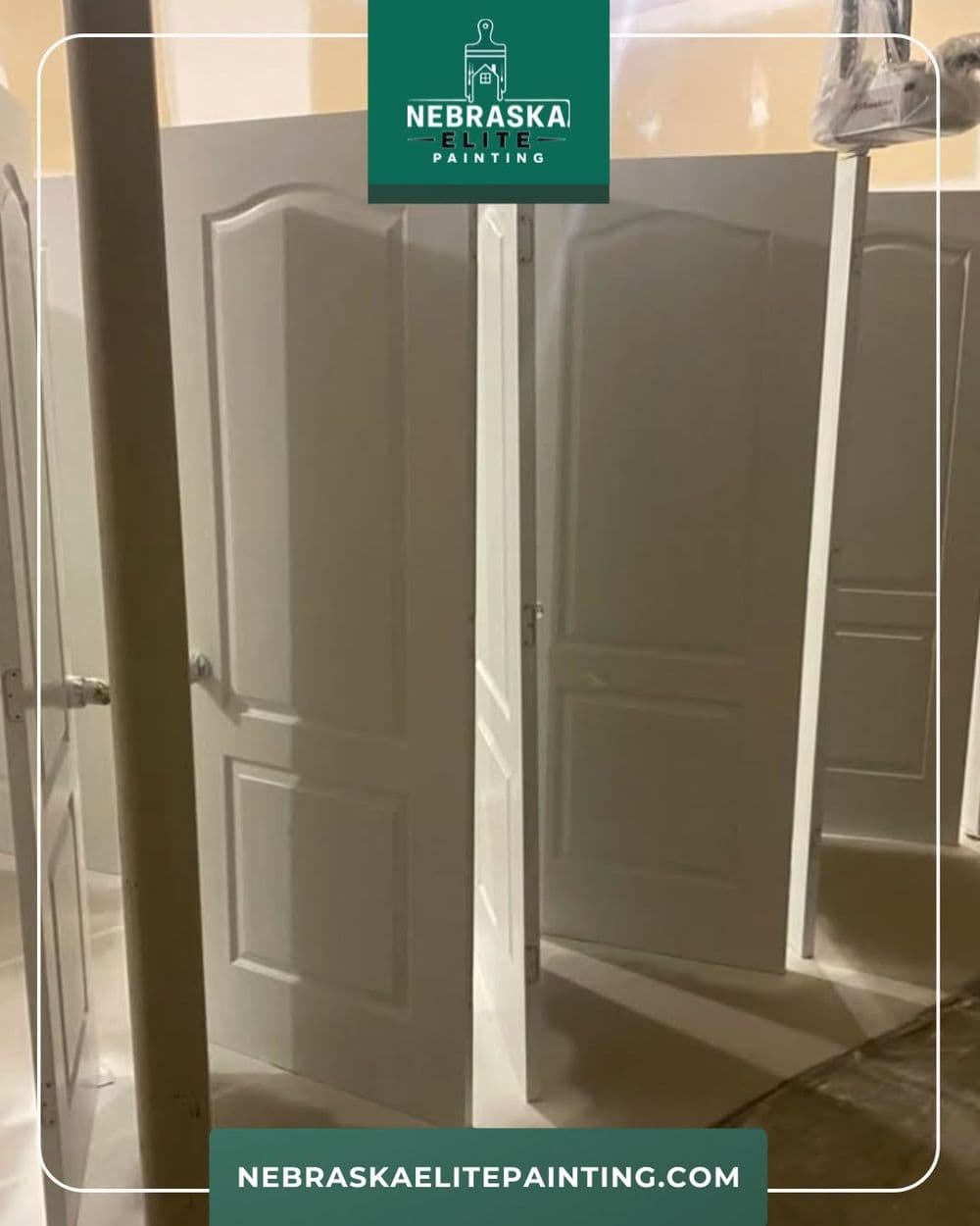 Freshly painted white doors in a well-lit workspace ready for installation. Nebraska Elite Painting.