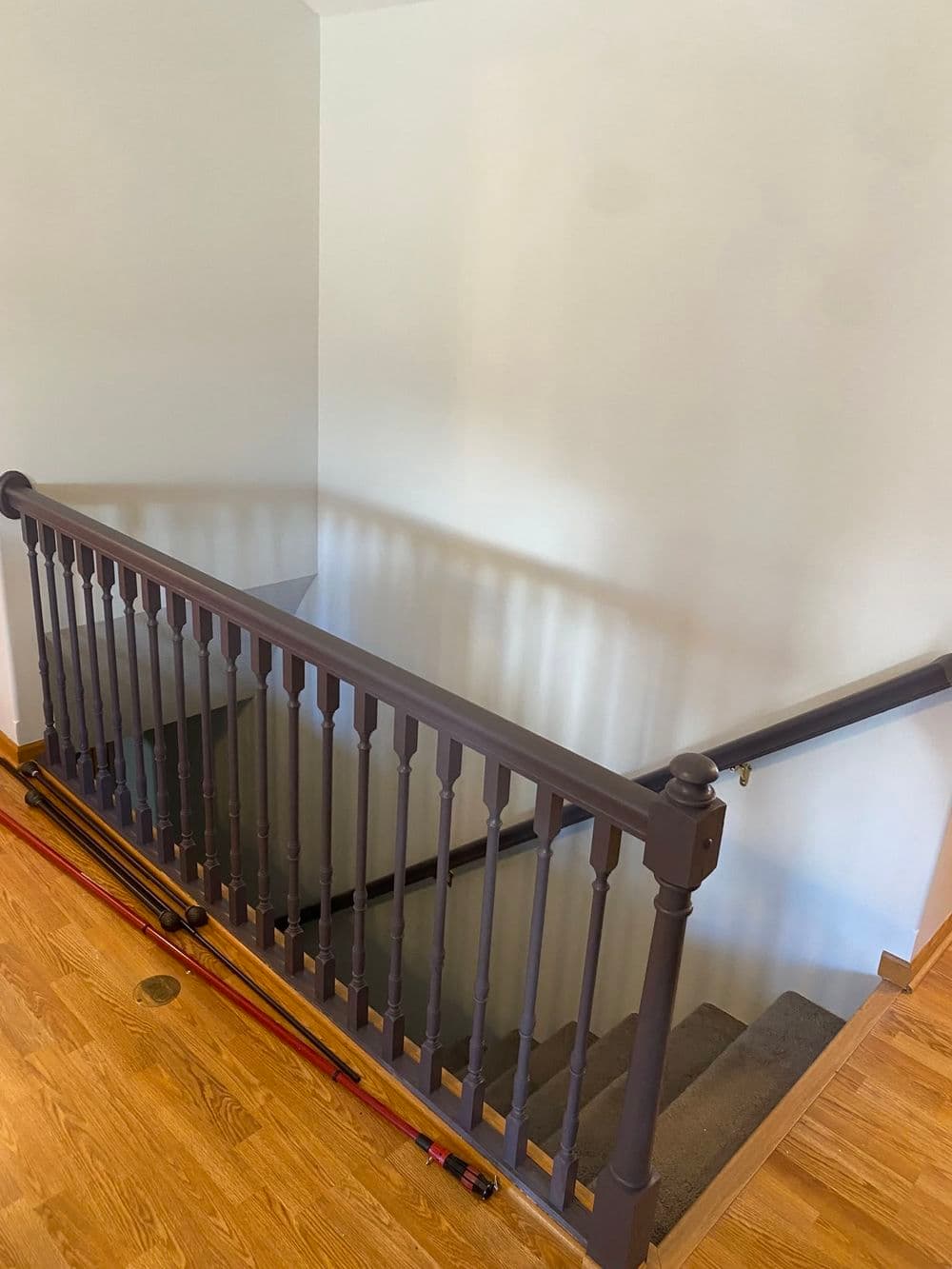 Interior staircase with wooden railing and carpeted steps, natural light illuminating space.