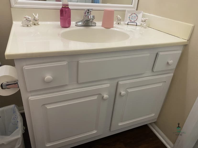 Vanity sink in a clean bathroom with decorative bunnies and lotions on the countertop.